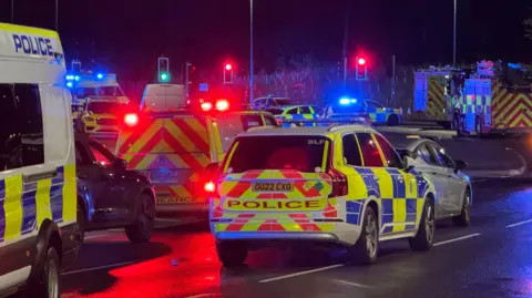 Matthew Webb/BBC Police vehicles at the scene of a multiple stabbing.