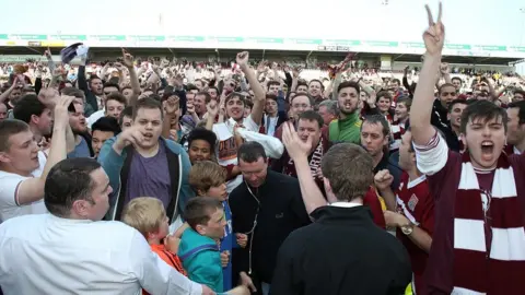 Getty Images Northampton Town fans celebrate survival after beating Oxford