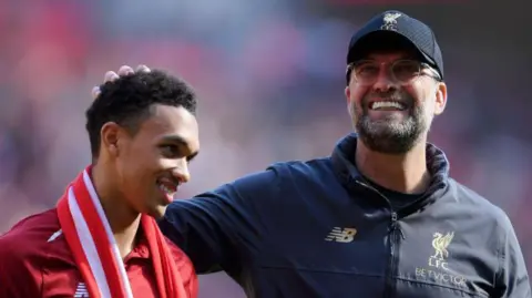 Jurgen Klopp, manager of Liverpool embraces Trent Alexander-Arnold of Liverpool