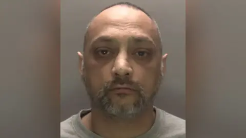 Leicestershire Police A mugshot of Raj Sidpara, a 50-year-old south-Asian with a short greying beard