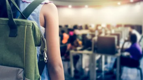 Getty Images Child enters almost empty classroom