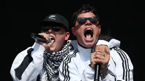 Kneecap's Mo Chara (L) and Moglai Bap (R) perform on stage.