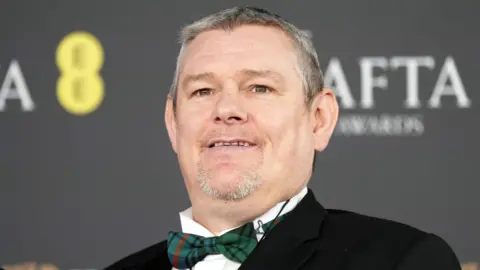 John Davidson in a bow tie on the Baftas red carpet