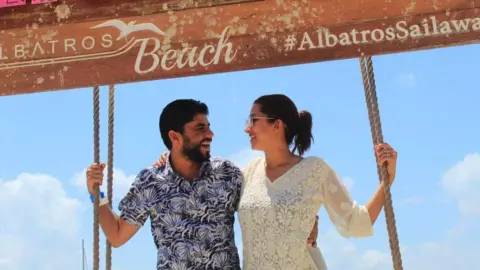 Family handout The couple posing by a sign in Mexico