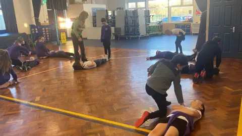 Elevate EBP Children taking part in Mini Medics first aid training in a school classroom.