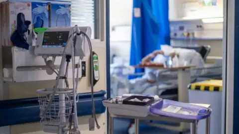 A wide shot of a hospital bed and equipment.