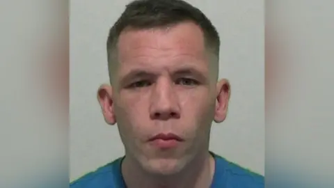 Northumbria Police A man with short brown hair and a blue T-shirt looks at the camera.