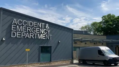 A grey building with the words Accident and Emergency Department.
