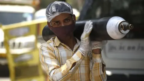 Getty Images A person waiting outside an oxygen-filling centre to refill their empty cylinder at Sector-14, IDC colony near Maharana Pratap Chowk, on April 26, 2021 in Gurgaon, India.