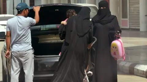 AFP Saudi women take out an infant trolley from the boot of a car outside a mall in the Saudi capital Riyadh (27 September 2017)