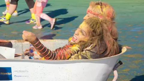 Ty Hafan Rob’s daughter Poppy completing Tŷ Hafan’s Rainbow Run fundraising event in a bathtub on wheels