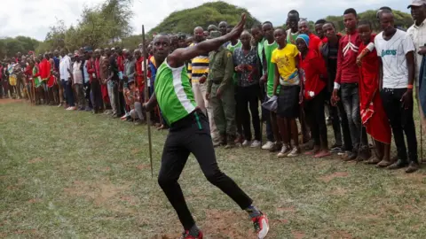 Reuters Spectators watch as a Maasai Moran throws a javelin