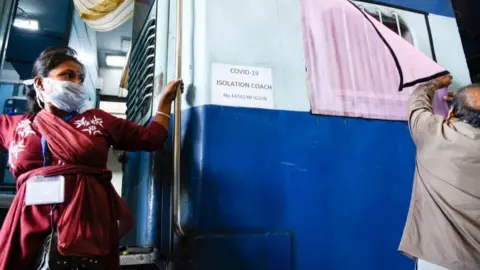 Getty Images Staff member of Northeast Frontier Railway (NFR) prepare train coaches to convert them into isolation wards for COVID-19 patients.