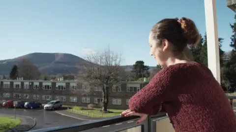 Helena Woodford looks out from her flat over neighbouring buildings and the countryside around Abergavenny