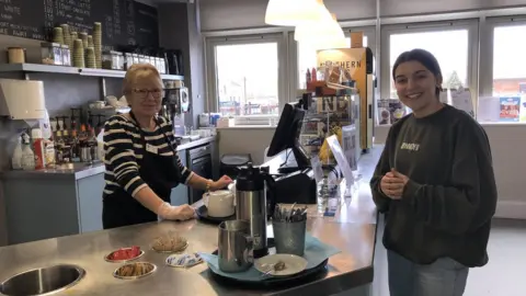 BBC / Naj Modak Lucy Riddle in library cafe with a member of canteen staff