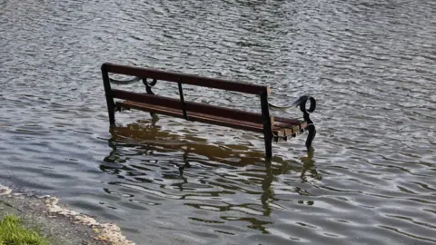 Oxfordshire County Council A bench in the middle of a water-logged area.