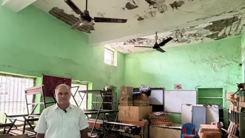 Geeta Pandey/BBC Satpal Narwat, a social worker in Faridabad, stands in a dilapidated classroom 