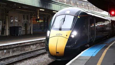 A Great Western Railway train is driving into Bristol Temple Meads. It is dark green with a yellow front.