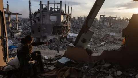 The Palestinian children of the EPA observe the sunset from the house destroyed in the field of refugees of Jabalia, north of the city of Gaza (February 11, 2025)