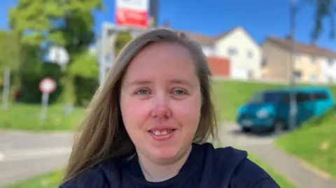 Woman smiling at the camera with blue eyes and long blonde hair