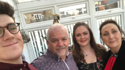 A group of people all smiling at the camera. There are two women and two men 