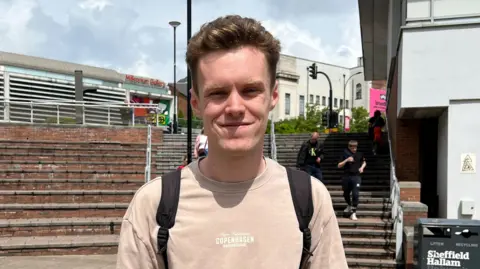 A man in a beige sweatshirt.