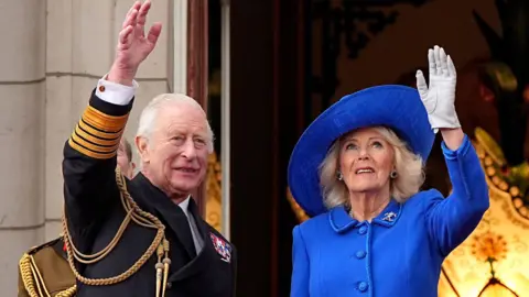 PA Media King Charles and Queen Camilla waved from the Palace balcony