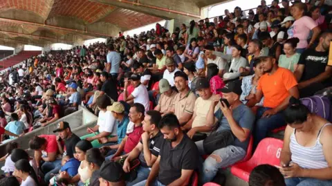 EPA People displaced by violence are shown seated inside the General Santander stadium in Cucuta, Colombia, 19 January 2025. 