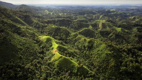 Panoramic view from a helicopter of tribal villages in jungle in the foot hills of Mount Turu, East Sepik Province, Papua New Guinea.