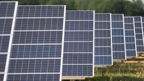generic image of a field filled with solar panels 