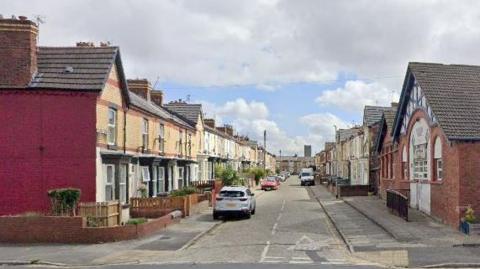 A general view of Lucerne Road, where two rows of yellow-bricked houses flank a grey-cobbled road