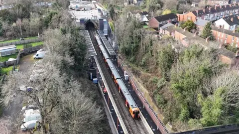 An overhead view of Moseley Village station. A train can be seen on the platform.