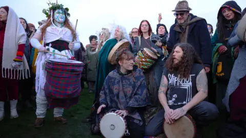 EPA Revellers drum together near Stonehenge.
