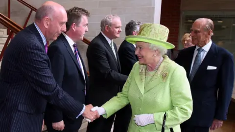 PA Media Queen Elizabeth II shakes hands with Peter Sheridan in Belfast in June 2012