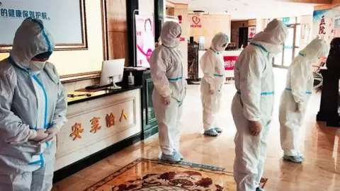 Covid testing workers hold a silence in Bazhou in China's western Xinjiang region