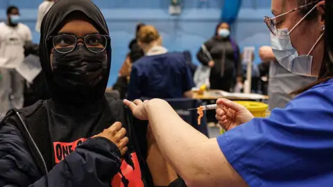 A student receives the Meningitis B vaccine at the University of Kent sports hall