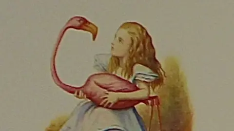 RBWM/Pan Macmillan A picture from the exhibition with Alice holding an flamingo-like bird.