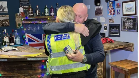 Mr Eamer hugging the policewoman who returned the medals