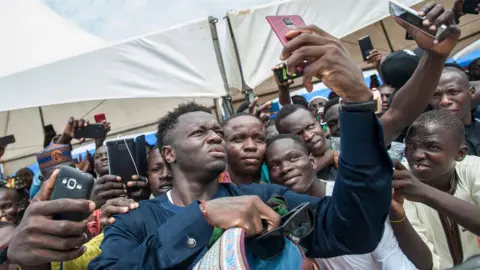 AFP Ghanaian footballer, Sulley Muntari, takes a selfie with fans at Independence Square the celebration of the Eid al-Fitr, on June 15, 2018 at the Independence Square in Accra