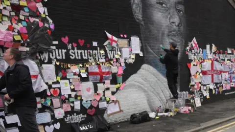 Getty Images Artist repairs defaced mural of Marcus Rashford