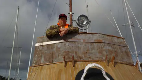 Jon Fieldhouse A man stood on a boat 