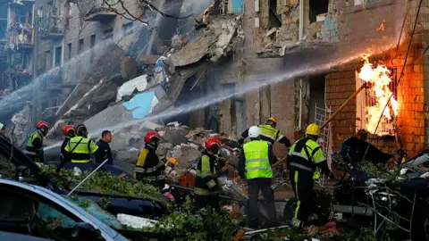 Firefighters work to put out a fire at the site of an apartment building hit during Russian drone and missile strikes. 23 June 2025