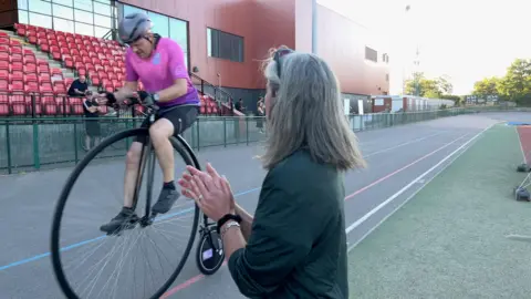 Julia cheers from the sidelines as Rolf whizzes past.