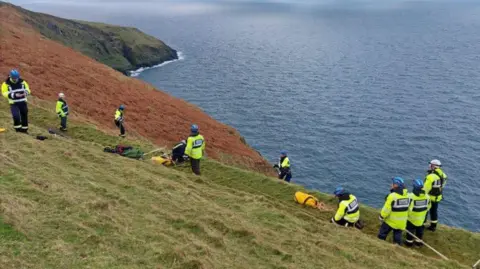 Peel Coastguard Rescue Team A coastguard team organising a rope rescue on the cliff edge