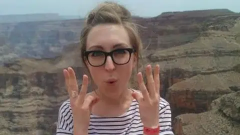 Supplied Louise is pictured holding her hands up to camera and smiling 