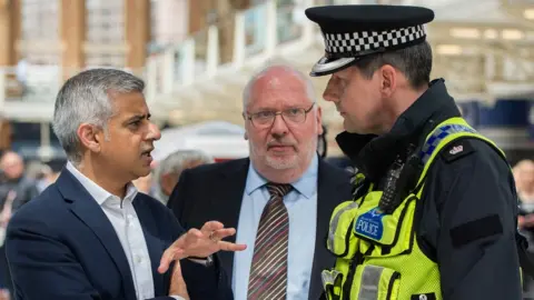 PA Media Mayor of London Sadiq Khan and Lord Harris during a routine operation with British Transport Police officers