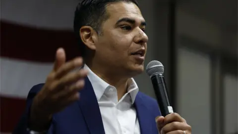 Getty Images Robert Garcia holds a microphone.