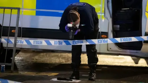 Matthew Horwood Officer photographs evidence on the ground