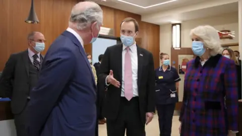 PA Media The Prince of Wales and Duchess of Cornwall talk with Health Secretary Matt Hancock (centre) during a visit to the Queen Elizabeth Hospital in Birmingham