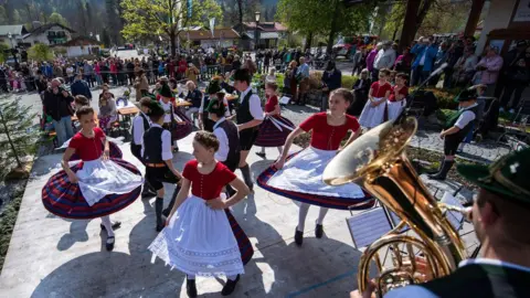 Getty Images Members of the 'D"Leonhardstoana' costume group wear traditional dresses as they dance during the maypole festival in southern Germany